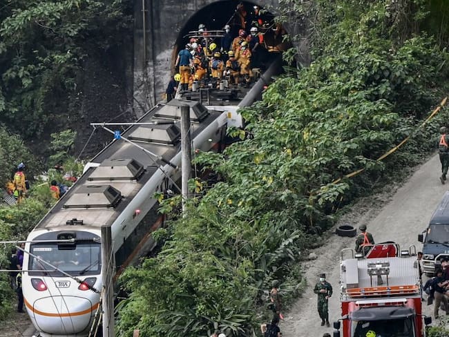 Esta foto muestra a los rescatistas en el lugar donde un tren descarriló dentro de un túnel en las montañas de Hualien, en el este de Taiwán el 2 de abril de 2021