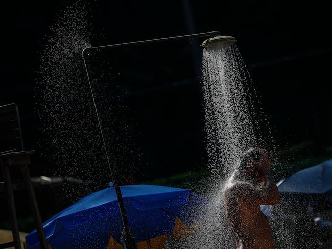Un hombre se refresca en una ducha en Río de Janeiro (Brasil). Según el Sistema de Alerta de Río, este domingo se registró una sensación térmica de 62,3ºC, con la temperatura oficial de 40,4ºC. 
(foto:   EFE/ Antonio Lacerda)