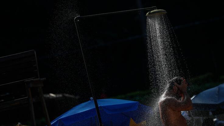 AME9618. RÍO DE JANEIRO (BRASIL), 17/03/2024.- Un hombre se refresca en una ducha este domingo en Río de Janeiro (Brasil). Según el Sistema de Alerta de Río, este domingo se registró una sensación térmica de 62,3ºC, con la temperatura oficial de 40,4ºC. EFE/ Antonio Lacerda