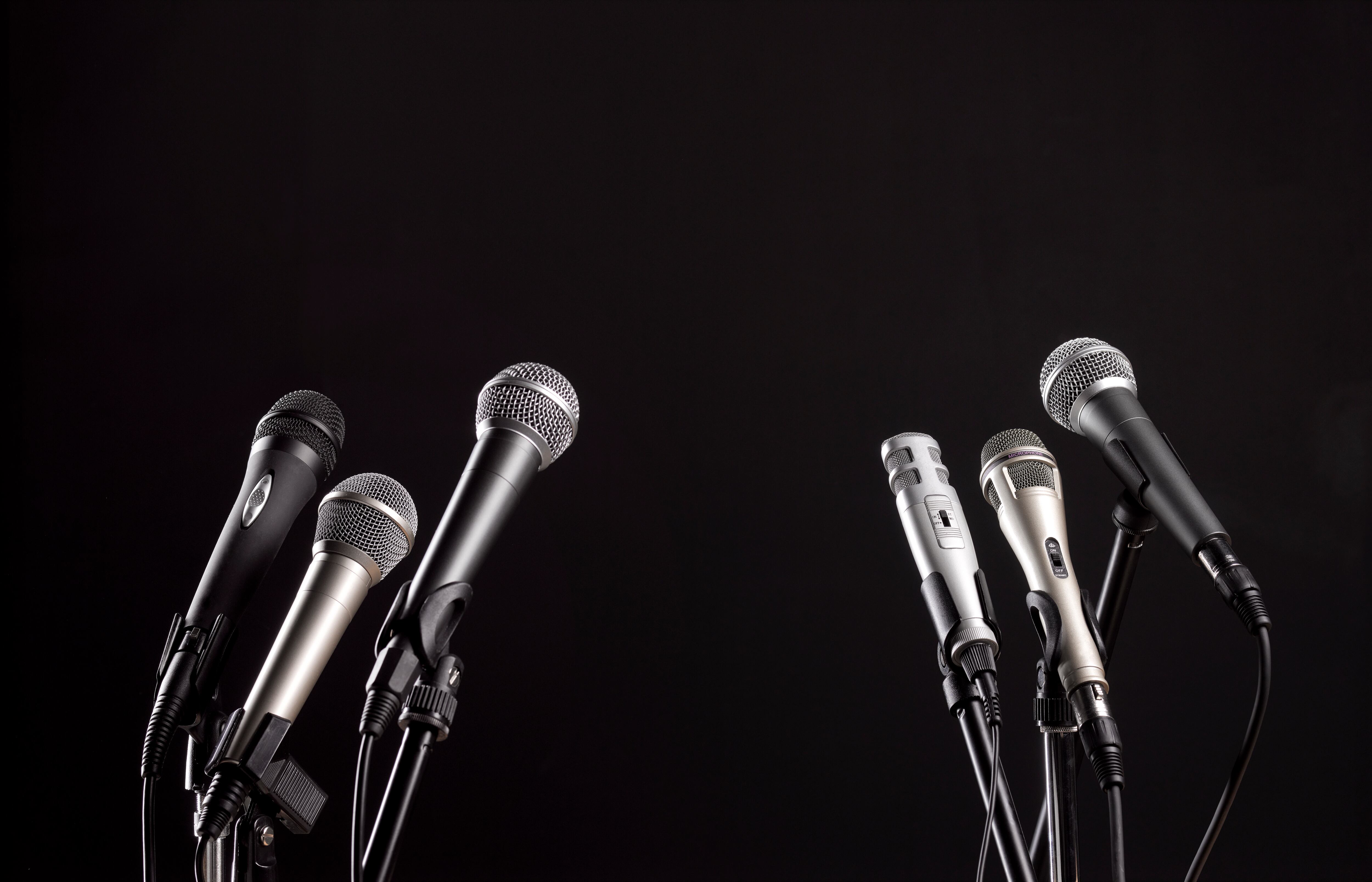 Close up of six microphones on a black background