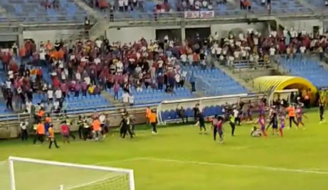 El momento en que los hinchas ingresan al terreno de juego para agredir a los jugadores del Unión Magdalena.
