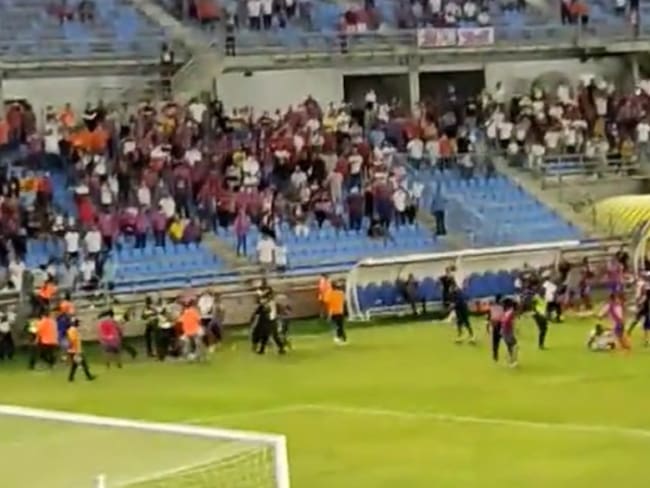 El momento en que los hinchas ingresan al terreno de juego para agredir a los jugadores del Unión Magdalena.