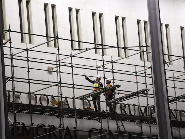 Workers build scaffolding near the signage for the "Donald J. Trump and John F. Kennedy Memorial Center for the Performing Arts" in Washington, DC, early on June 13, 2026. A US federal judge on June 12 rejected a bid by the board of the Kennedy Center and the Justice Department to halt the removal of President Donald Trump's name from the performing arts venue. District Judge Christopher Cooper, in a ruling last month, ordered Trump's name taken off the iconic building in the nation's capital by Friday, June 12, 2026. (Photo by Alex WROBLEWSKI / AFP)