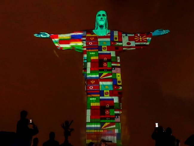 Cristo Redentor iluminado con las banderas de países afectados por COVID-19