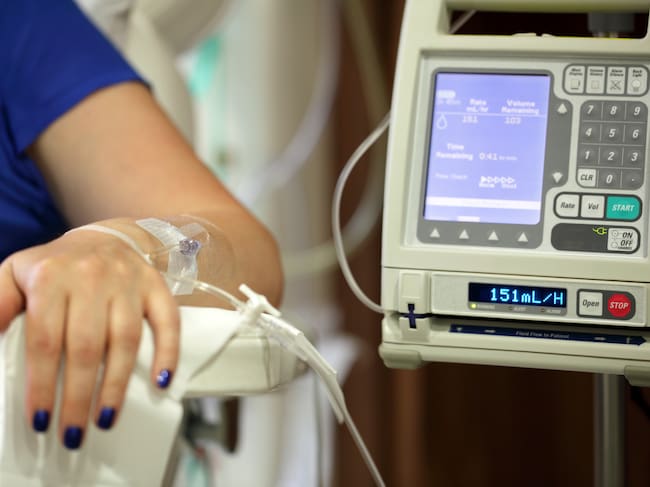 Infusion pump feeding IV drip into patients arm focus on needle