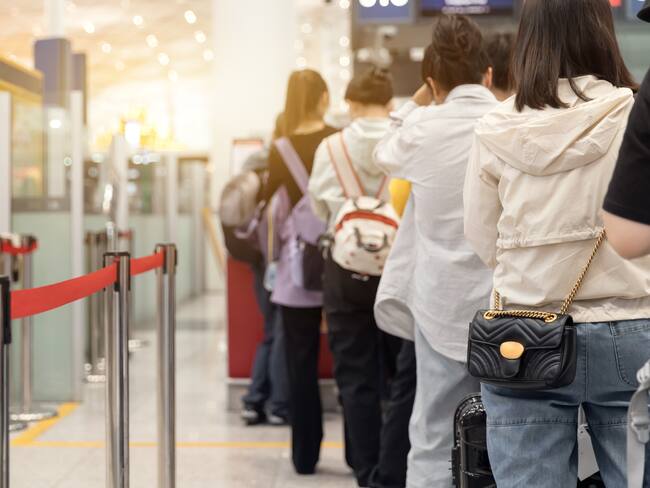 Passengers lined up at the airport to check in their luggage.