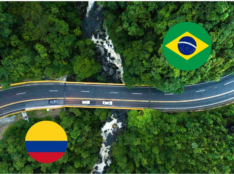 Carretera que pasa sobre un río entre los bosques de Brasil / Banderas de Brasil y Colombia (Getty Images)