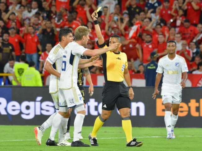 El árbitro Bismarks Santiago amonesta a Andrés Llinás tras sancionar el penalti para el América / Colprensa.