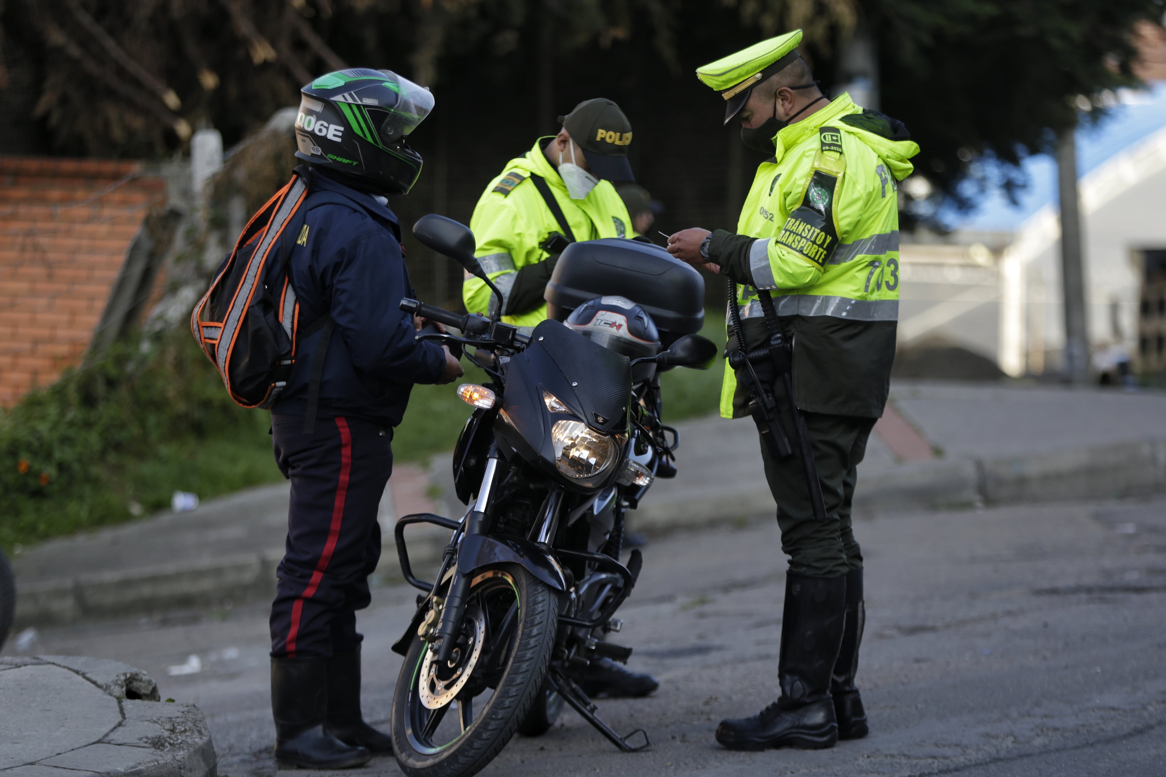 Agentes de la Policía de Tránsito y Transporte revisando documentos de un motociclista (Foto vía COLPRENSA)