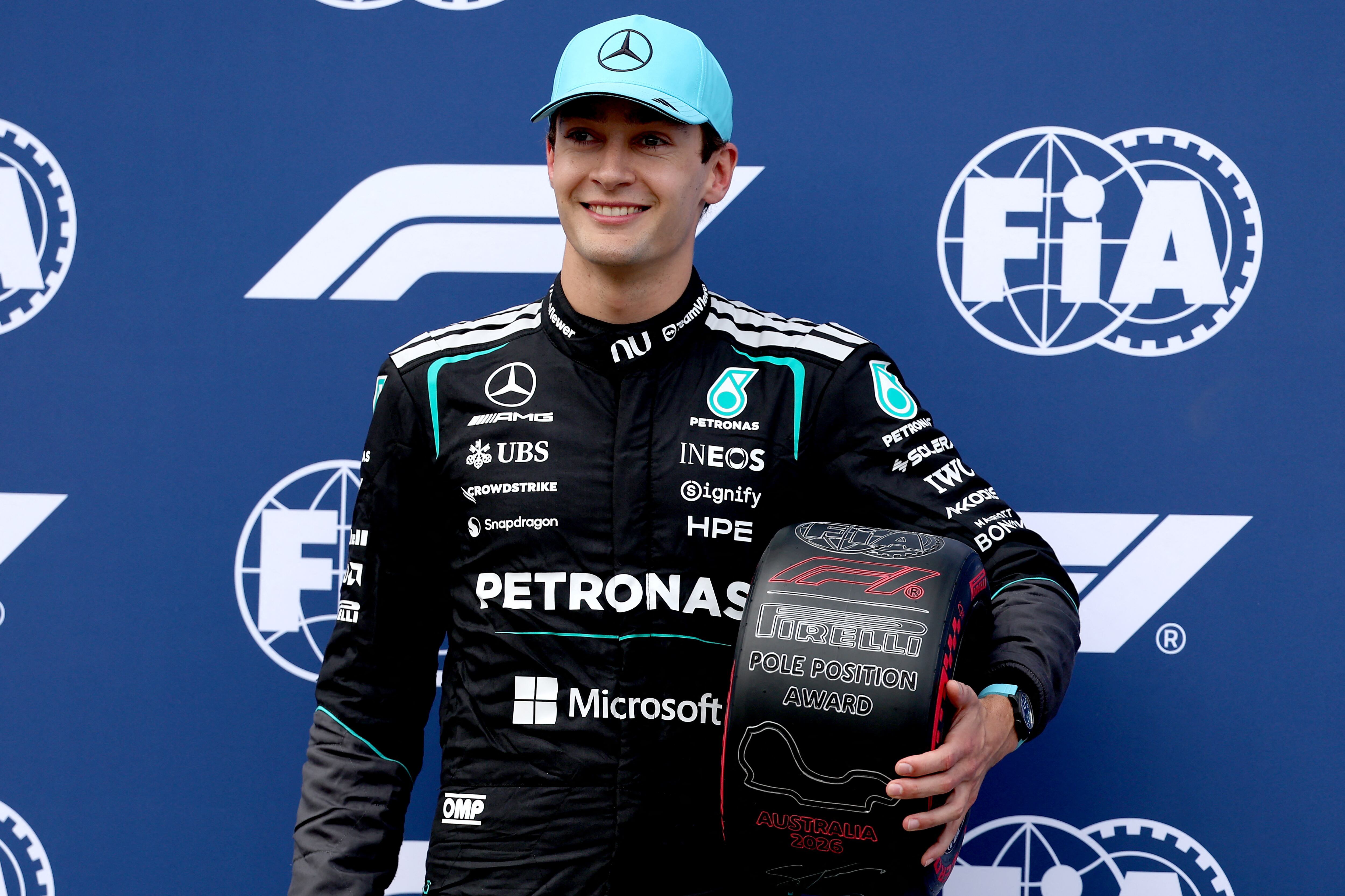 Pole position winner Mercedes' British driver George Russell celebrates on stage after the qualifying session after the qualifying session of the Formula One Australian Grand Prix at the Albert Park Circuit in Melbourne on March 7, 2026. (Photo by Martin KEEP / AFP) / -- IMAGE RESTRICTED TO EDITORIAL USE - STRICTLY NO COMMERCIAL USE --