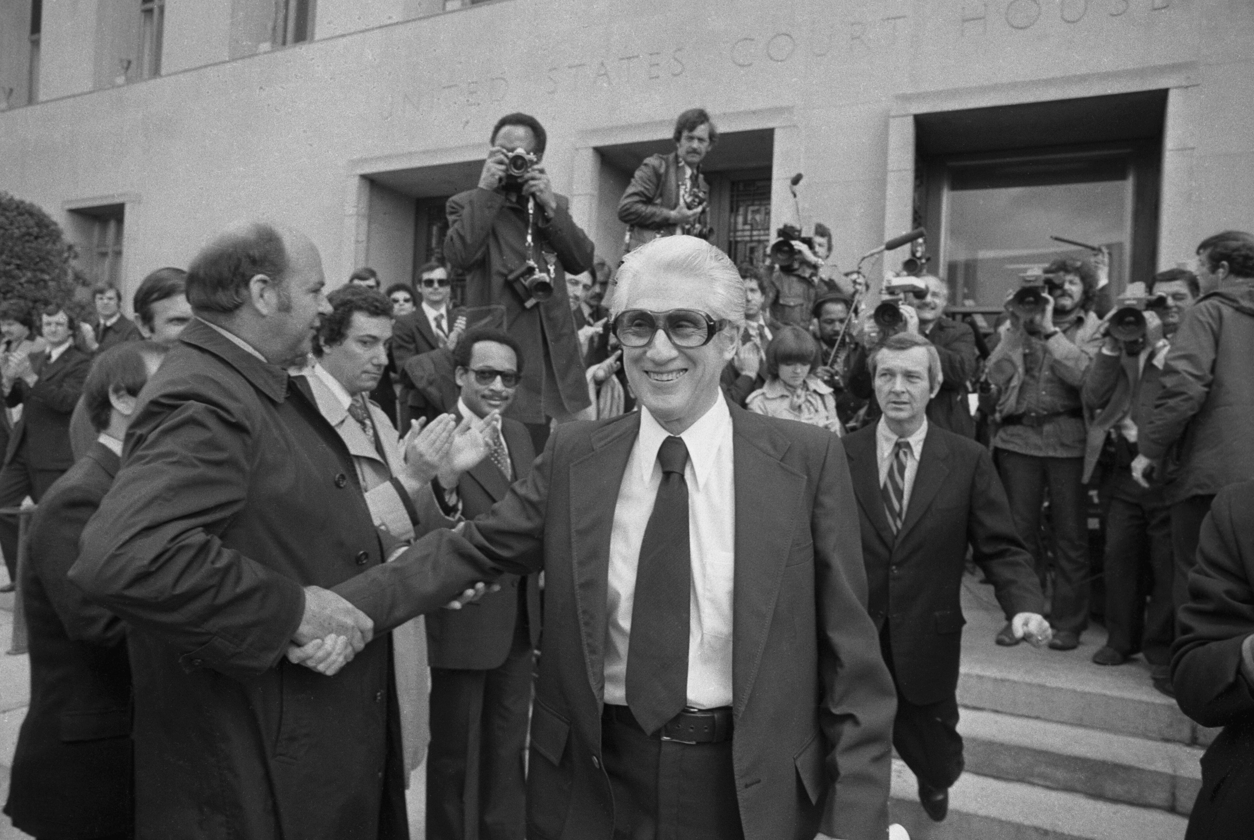 (Original Caption) Former FBI associate director Mark Felt (right) gets well wishes from some former and present FBI agents as he leaves US District court 4/20 after pleading innocent to federal charges involving alleged illegal wiretaps in the investigation of Weatherman terrorists.