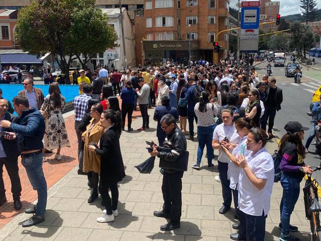 Personas se reúnen afuera de un edificio luego de ser evacuadas tras un temblor de 6.1 hoy, en Bogotá (Colombia). EFE/ Diana Sánchez