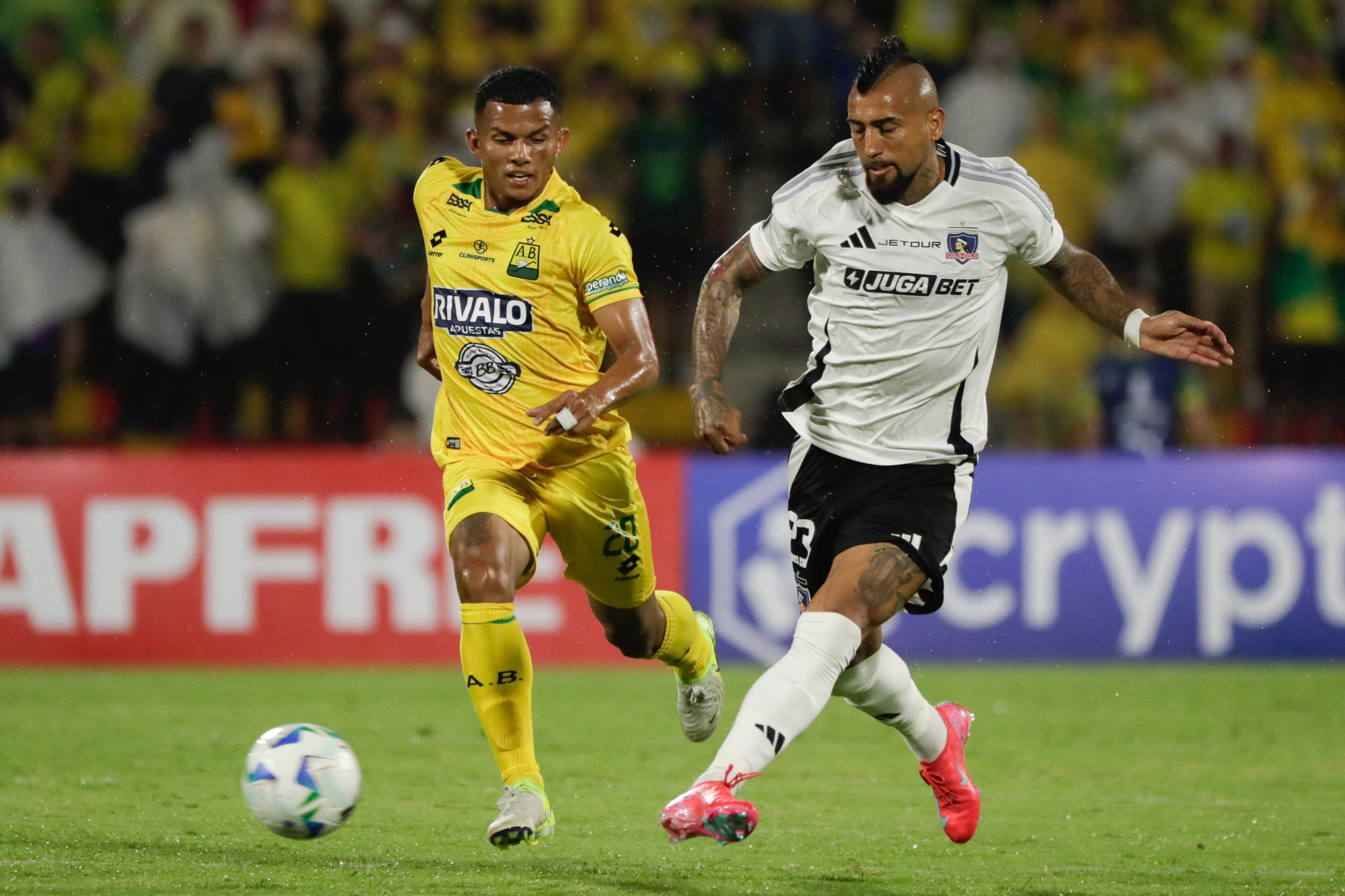 Aldair Enrique Zárate (i) de Bucaramanga disputa un balón con Arturo Vidal de Colo-Colo, en un partido de la fase de grupos de la Copa Libertadores en el estadio Américo Montanini en Bucaramanga (Colombia). EFE/ Carlos Ortega