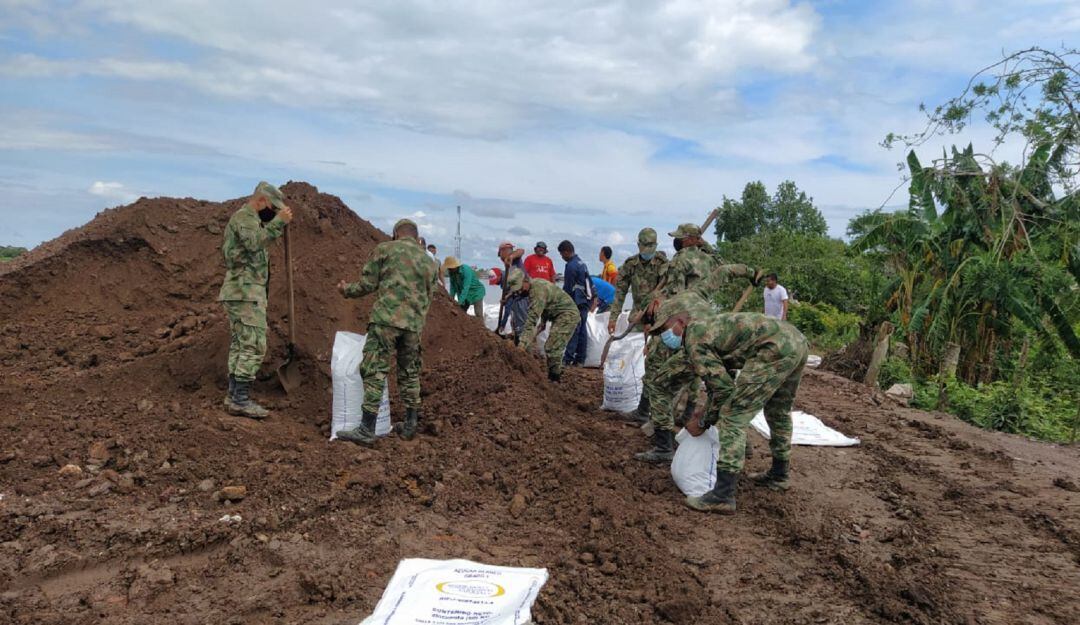 Con palas, botas y guantes se instalan barreras con costales de arena para dar una solución rápida a las inundaciones