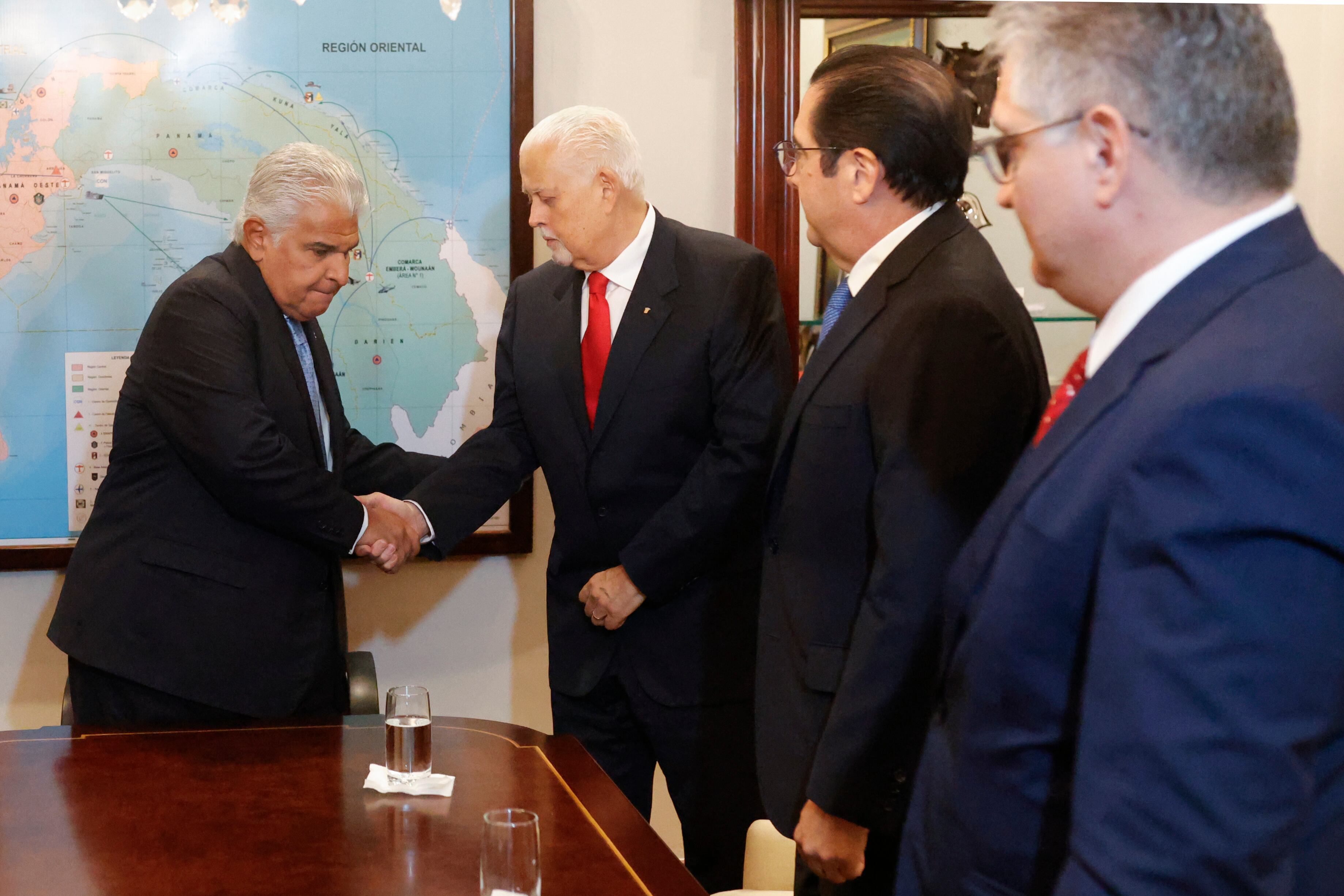 AME7202. CIUDAD DE PANAMÁ (PANAMÁ), 23/12/2024.- El presidente de Panamá, José Raúl Mulino (i), estrecha la mano del expresidente Ernesto Pérez Balladares, durante una reunión este lunes, en la Ciudad de Panamá (Panamá).