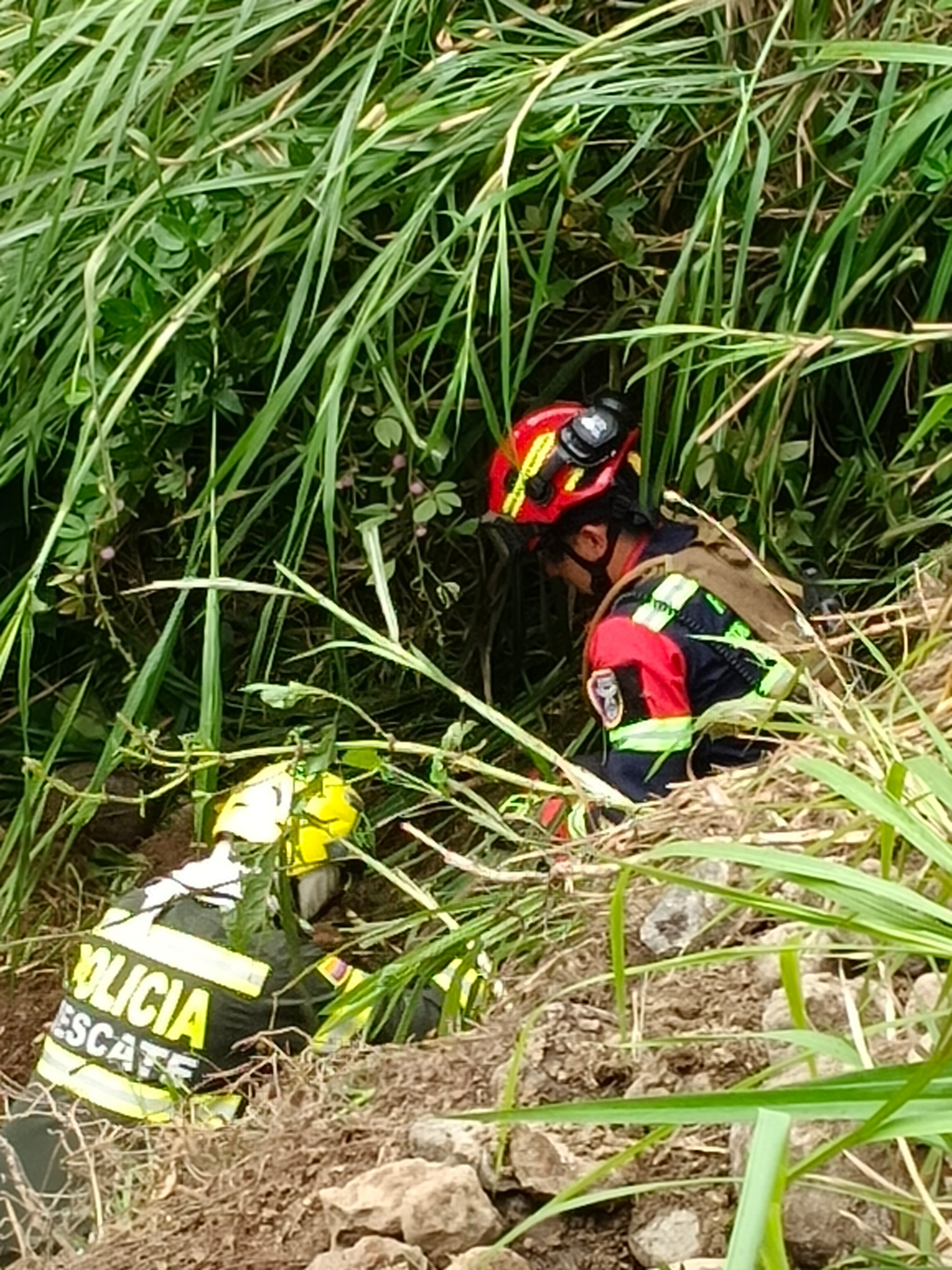 Dos integrantes de los organismos de socorro recuperando el cuerpo tapado por material rocoso. Foto suministrada.