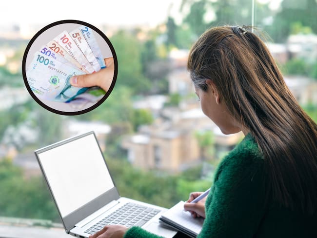 Mujer anotando información en un cuaderno mientras sostiene un portátil junto a unos billetes (Getty Images)