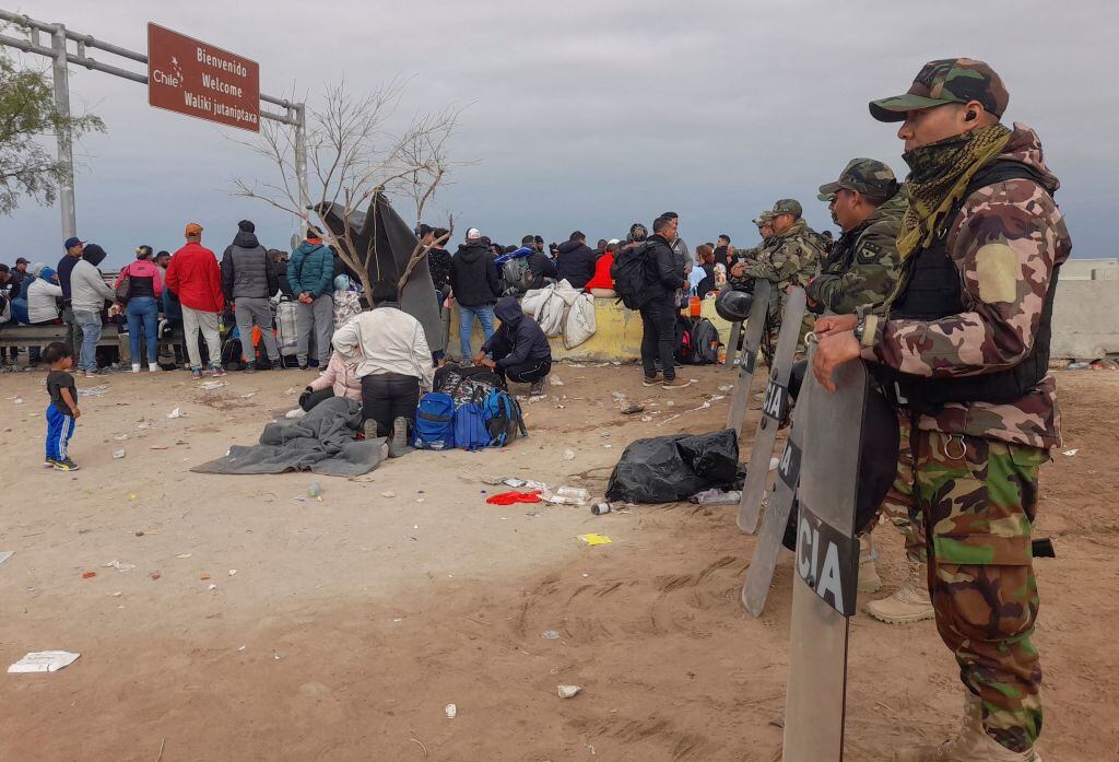 Peruvian police officers stand guard at a camp of migrants of various nationalities who remain stranded in the no-man's land in the border between Peru and Chile. Photo by Javier Rumiche / AFP) (Photo by JAVIER RUMICHE/AFP via Getty Images)