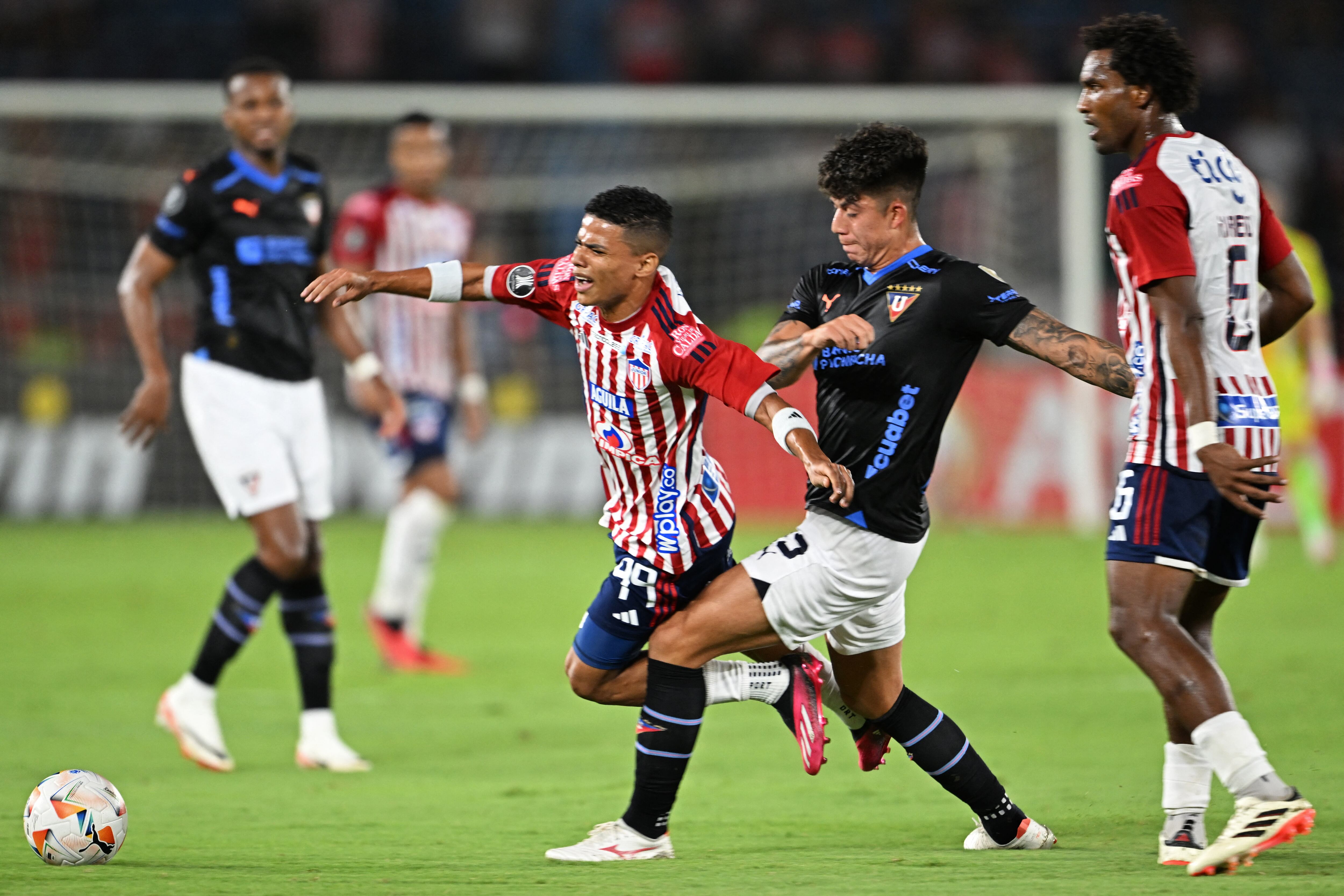 José Enamorado recibe una falta de un jugador de Liga de Quito. (Photo by LUIS ACOSTA/AFP via Getty Images)