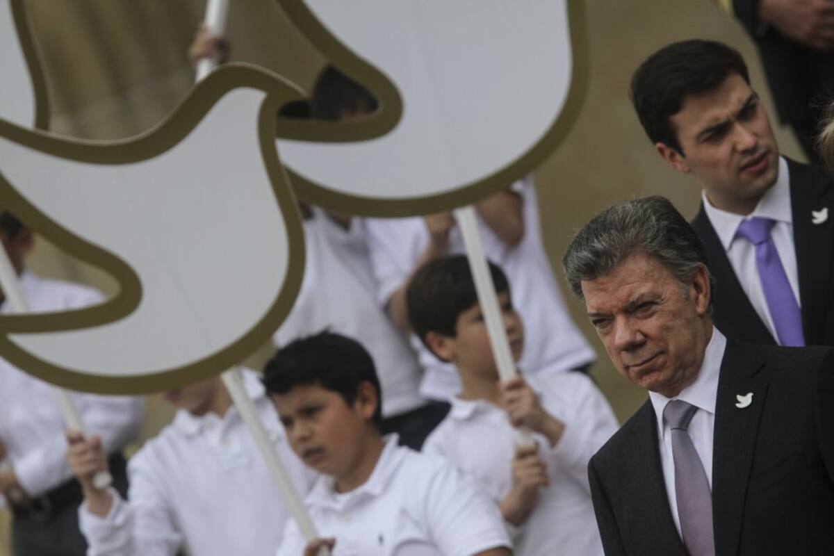 El presidente Juan Manuel Santos junto al símbolo de la paz. 