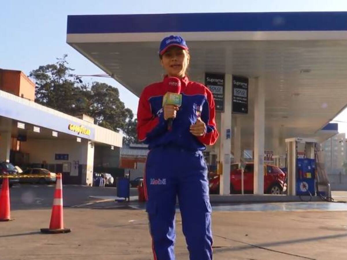 Caracol Radio en los zapatos de una trabajadora de estación de gasolina