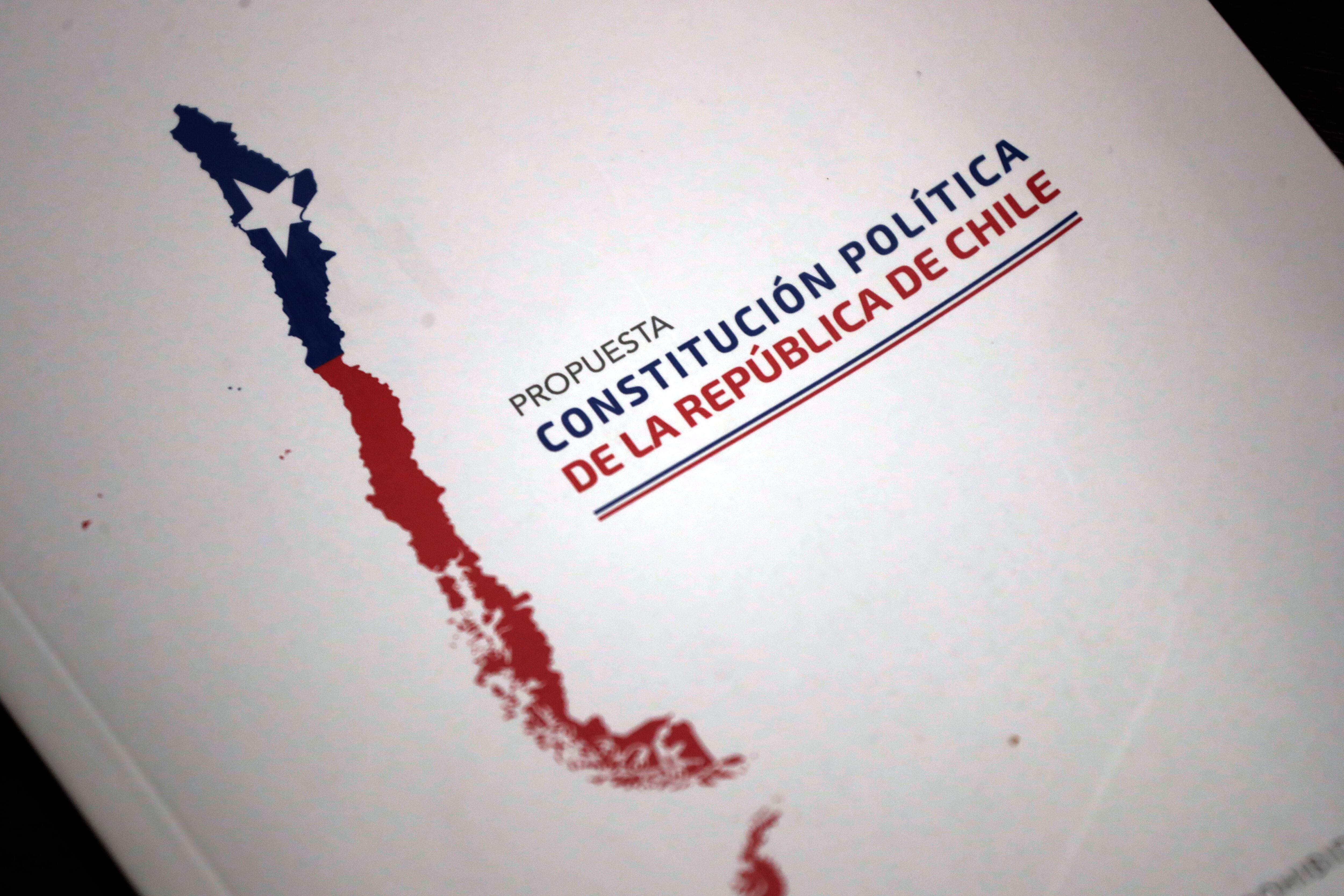 AME4277. SANTIAGO (CHILE), 14/12/2023.- Fotografía del libro de la Propuesta Constitucional de Chile, el 13 de diciembre 2023, en Santiago (Chile). El rumbo que tomó el segundo proceso constituyente atrapó al progresismo chileno en una gran paradoja: tener que defender la Constitución vigente, que repudió durante décadas por su origen dictatorial, ante la posibilidad de aprobarse una propuesta de carta magna con sello conservador y considerada más regresiva que la heredada del régimen. El contrasentido es tal que la extrema derecha, que nunca apostó por cambiar el texto fundamental vigente, junto a la derecha tradicional, defienden en el plebiscito de este domingo sustituir el redactado actual; mientras que quienes siempre habían insistido en una nueva propuesta ahora apuestan por mantenerlo. EFE/ Elvis González