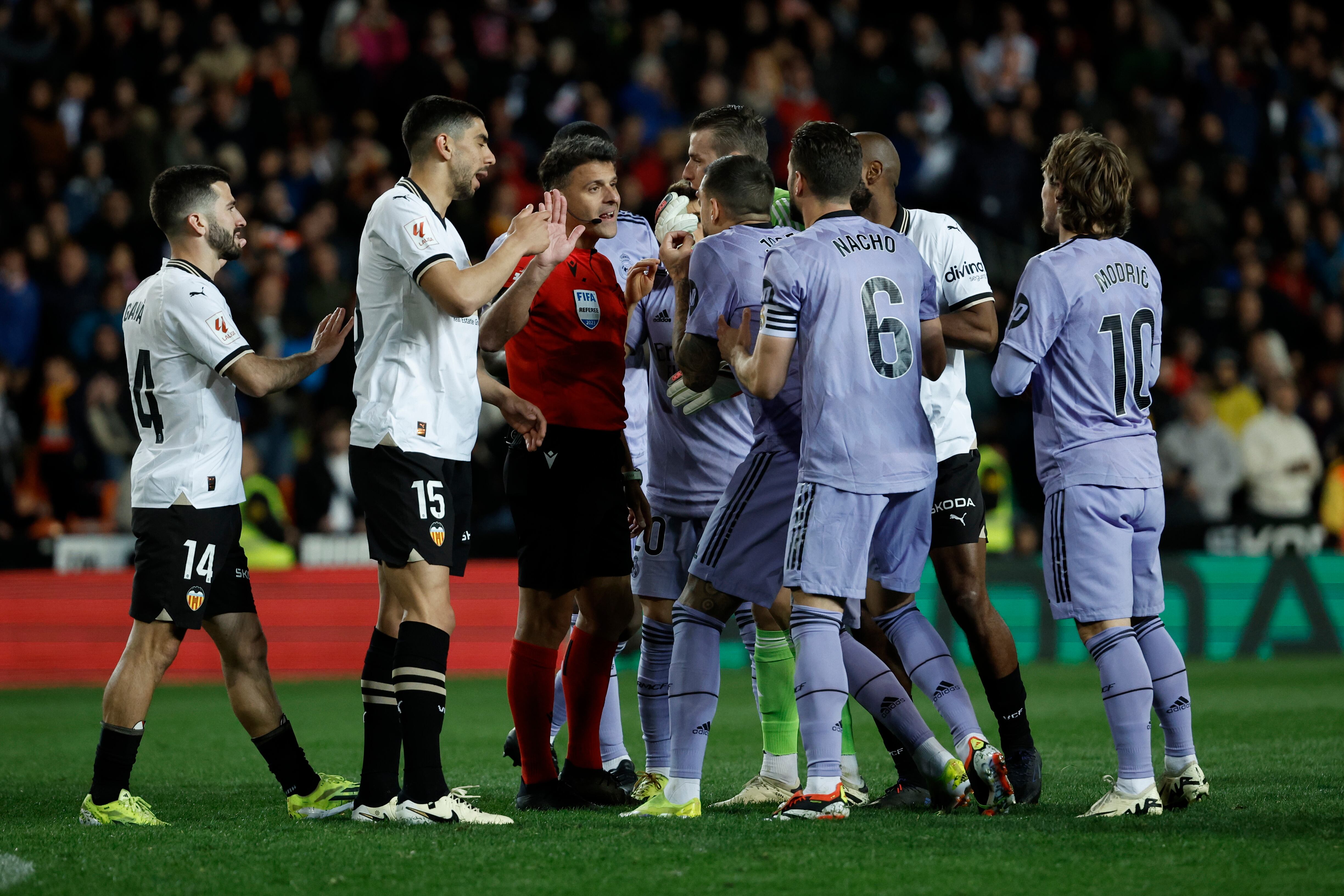 Los jugadores del Real Madrid protestan al colegiado Gil Manzano el gol anulado en el último momento del encuentro correspondiente a la jornada 27 de Primera División entre Valencia y el cuadro merengue. EFE / Biel Aliño.