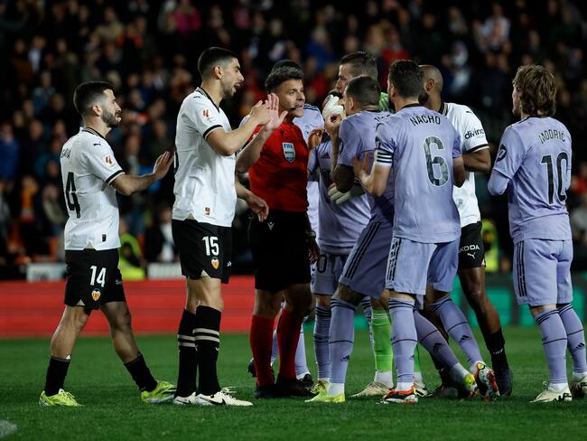 Los jugadores del Real Madrid protestan al colegiado Gil Manzano el gol anulado en el último momento del encuentro correspondiente a la jornada 27 de Primera División entre Valencia y el cuadro merengue. EFE / Biel Aliño.