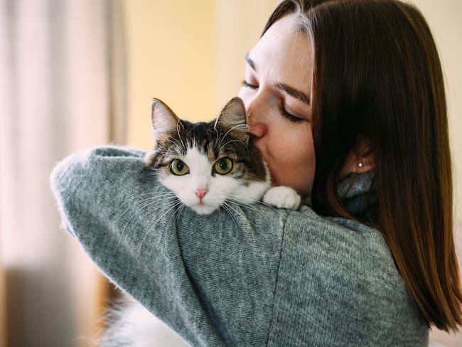 Mujer abrazando a su gato (Foto vía Getty Images)