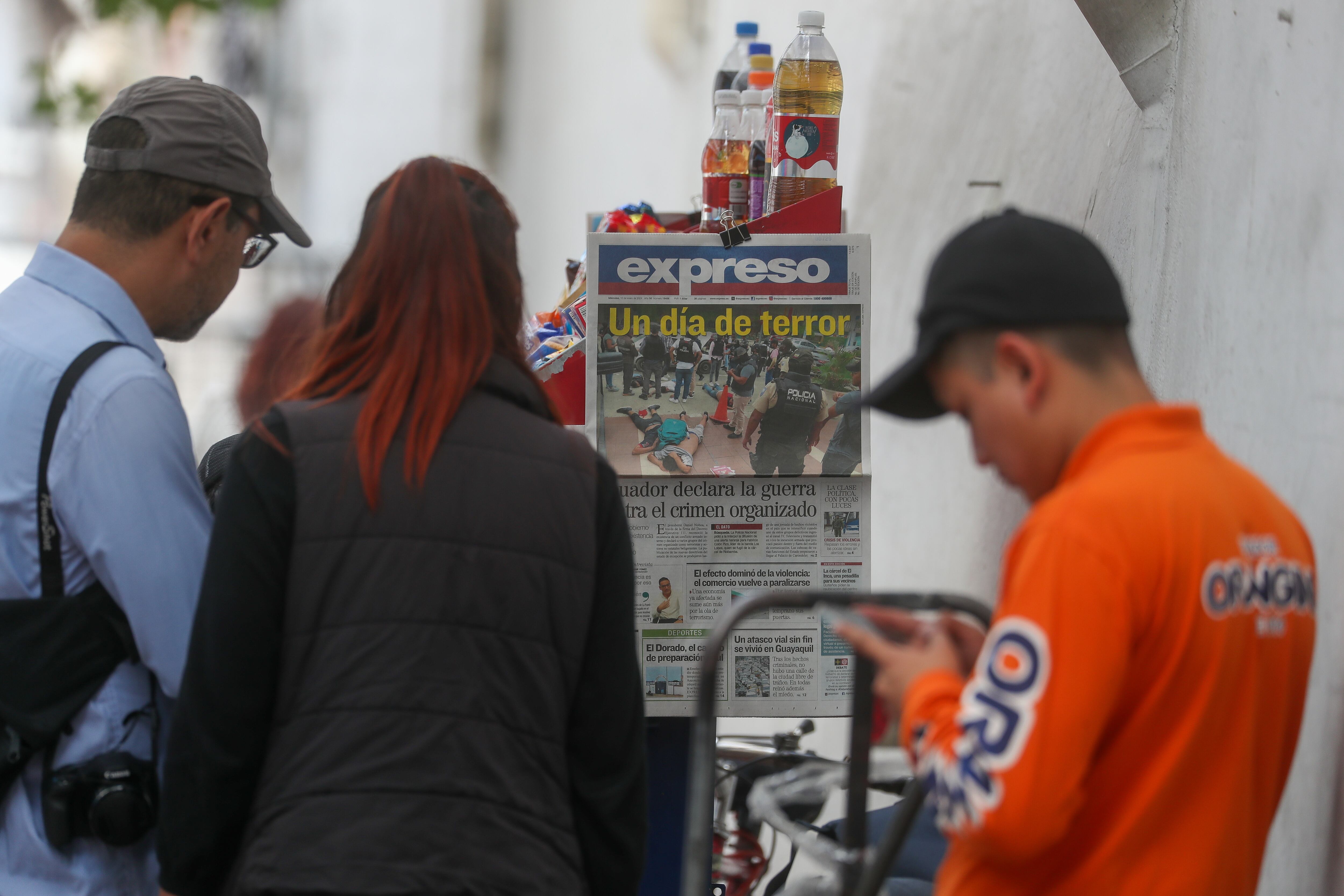 Personas leen las portadas de los periódicos hoy, en Quito (Ecuador). Los Estados miembros del Mercosur condenaron enérgicamente los actos de violencia perpetrados por el crimen organizado en Ecuador, según un comunicado difundido este miércoles por la Cancillería brasileña. EFE/ José Jácome