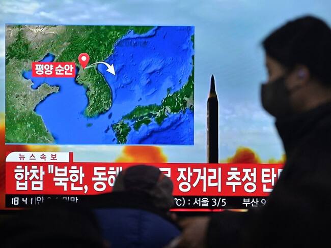 A woman walks past a television showing a news broadcast with file footage of a North Korean missile test, at a railway station in Seoul on February 18, 2023. - North Korea fired a suspected long-range ballistic missile on February 18, South Korea&#039;s military said, Pyongyang&#039;s first test in seven weeks that comes days before Seoul and Washington are due to start joint tabletop exercises. (Photo by Anthony WALLACE / AFP) (Photo by ANTHONY WALLACE/AFP via Getty Images)