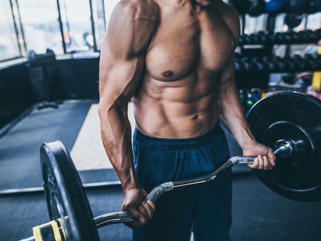 Hombre trabajando peso para aumento de masa muscular // Getty Images