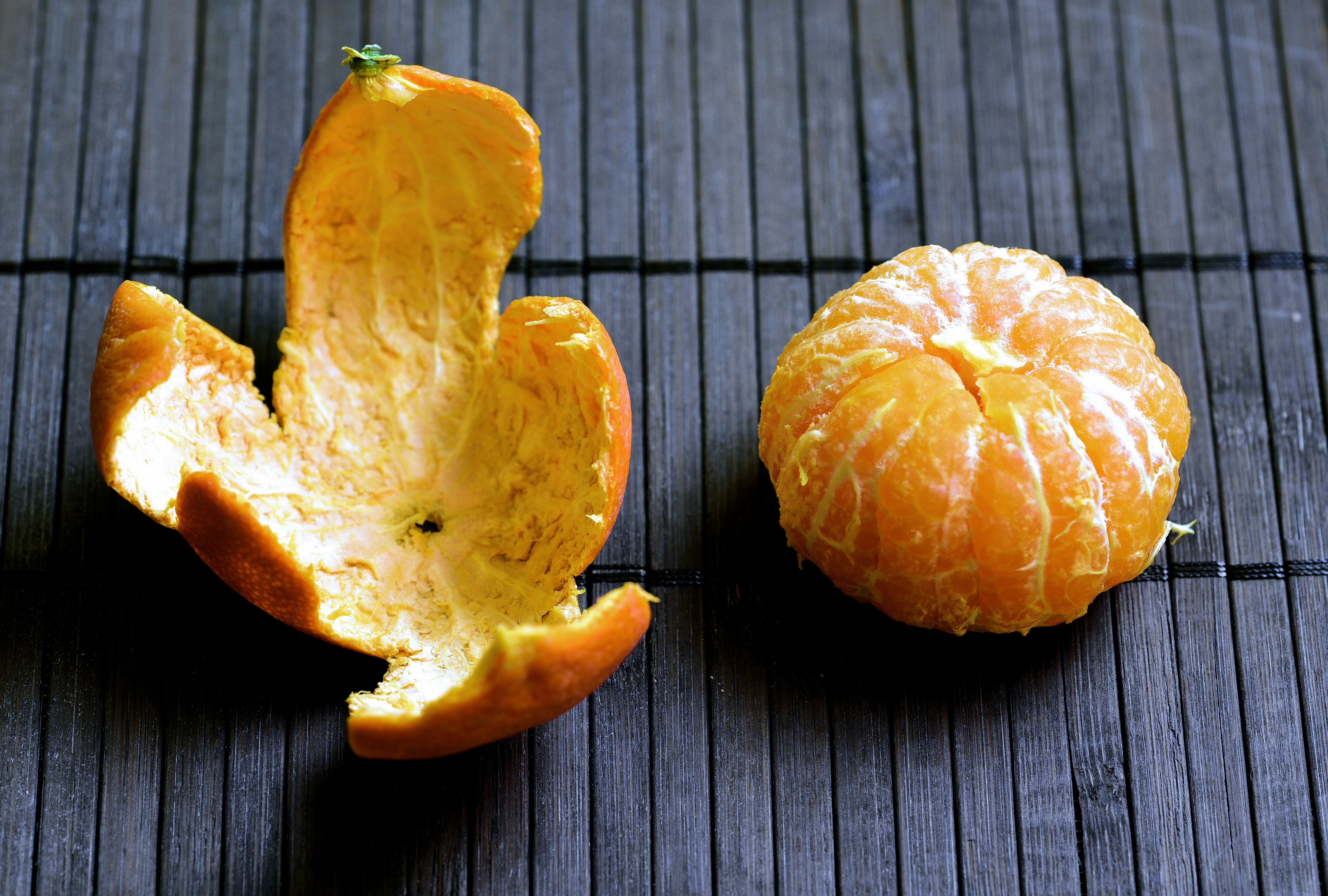 Mandarina 'pelada' y al lado su cáscara (Foto vía Getty Images).