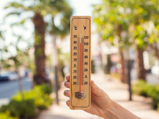 Persona midiendo la temperatura del ambiente en una ciudad (Foto vía Getty Images)