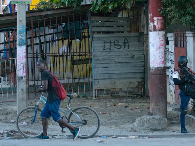 AME4788. PUERTO PRÍNCIPE (HAITÍ), 02/03/2024.- Un policía vigila durante los actos de saqueo en el centro de la ciudad, este sábado en Puerto Príncipe (Haití). Continúan los tiroteos esporádicos y los actos de saqueo este sábado en varios barrios el área metropolitana de Puerto Príncipe, creando una situación de miedo, incertidumbre y alerta constantes en la población. EFE/ Siffroy Clarens
