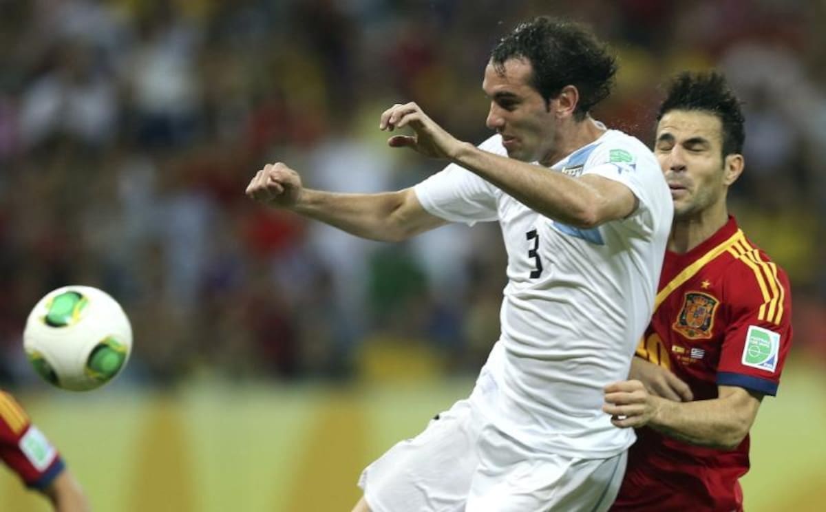 Fábregas choca con Godín en una acción de juego. Foto: EFE