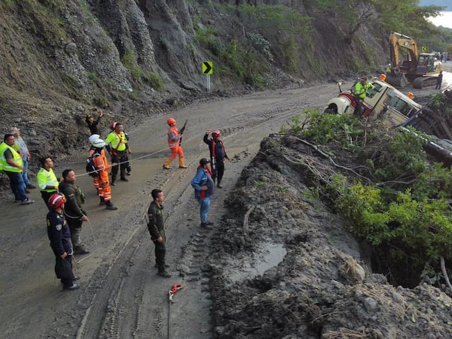 Personal de la Seccional de Tránsito y Transporte del Huila regula el paso vehicular en un solo carril en el sector de Los Altares, mientras continúan las labores de remoción de escombros tras el deslizamiento de tierra. Foto: Policía Huila.