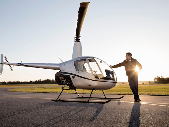 Piloto de helicóptero al lado de su aeronave / Foto: GettyImages