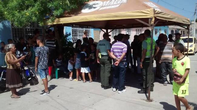 Los vecinos y amigos en las afueras de la casa del patrullero en el barrio Rebolo