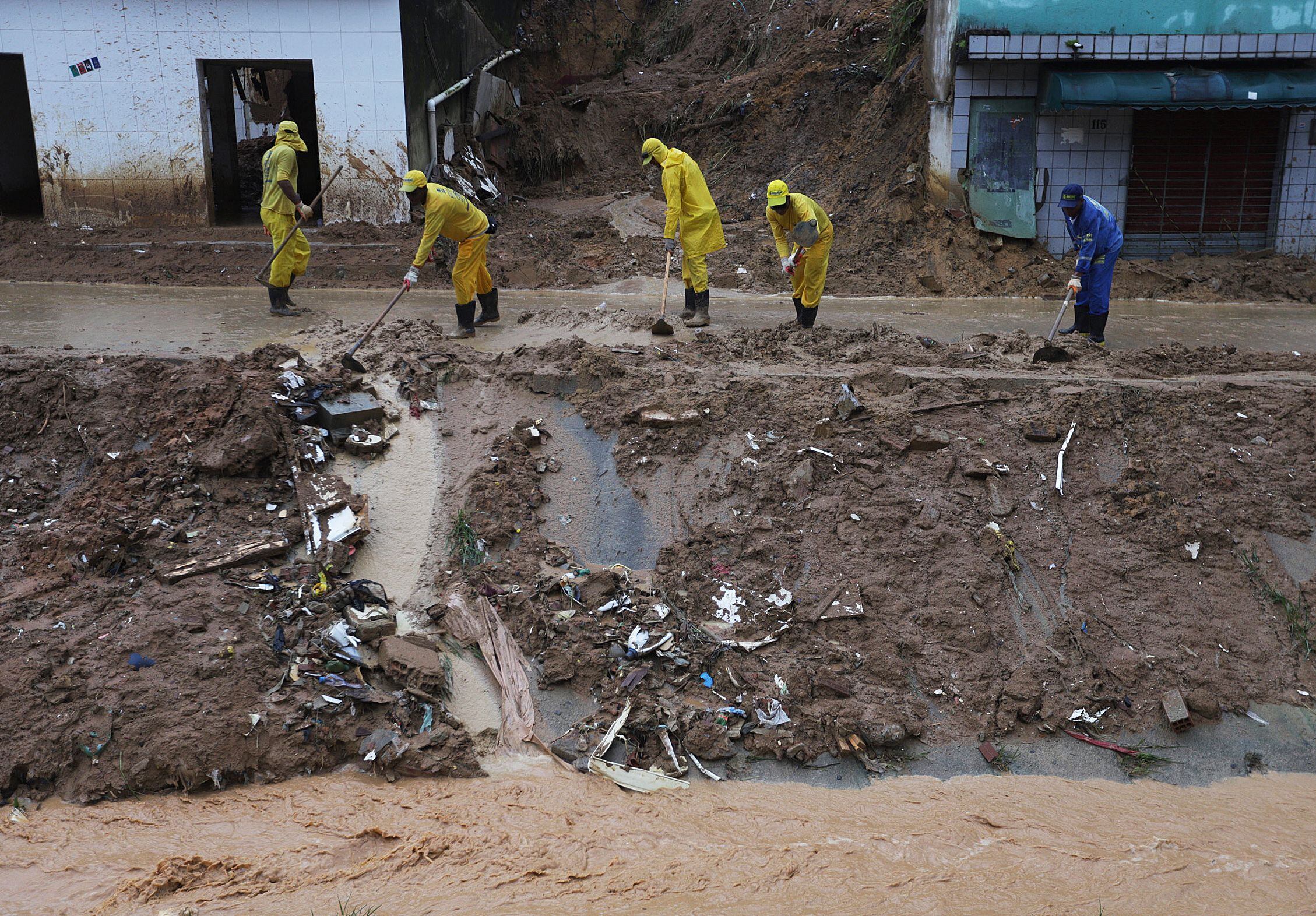Cleaning crews work at the scene of a landslide in the community Jardim Monte Verde, Ibura neighbourhood, in Recife, Pernambuco State, Brazil, on May 30, 2022. - Torrential rains in northeastern Brazil have left at least 79 people dead and dozens missing, civil defense officials said Sunday, as rescuers capitalized on a lull in downpours to search for survivors. (Photo by Sergio MARANHAO / AFP) (Photo by SERGIO MARANHAO/AFP via Getty Images)