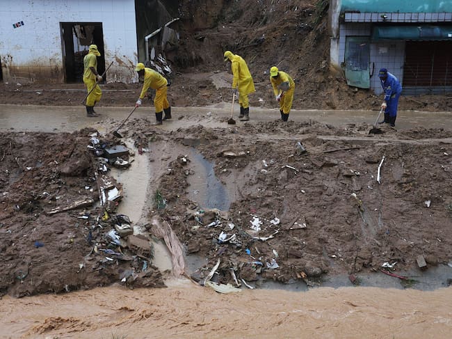 Cleaning crews work at the scene of a landslide in the community Jardim Monte Verde, Ibura neighbourhood, in Recife, Pernambuco State, Brazil, on May 30, 2022. - Torrential rains in northeastern Brazil have left at least 79 people dead and dozens missing, civil defense officials said Sunday, as rescuers capitalized on a lull in downpours to search for survivors. (Photo by Sergio MARANHAO / AFP) (Photo by SERGIO MARANHAO/AFP via Getty Images)