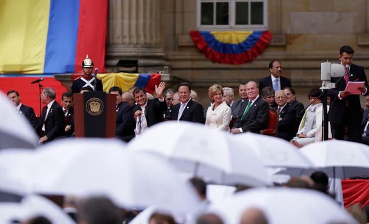 El presidente de Ecuador Rafael Correa saluda mientras el mandatario de Panamá, Juan Carlos Varela, su esposa Lorena Castillo de Varela y el rey Juan Carlos de Borbón observan la ceremonia de posesión del presidente Santos.