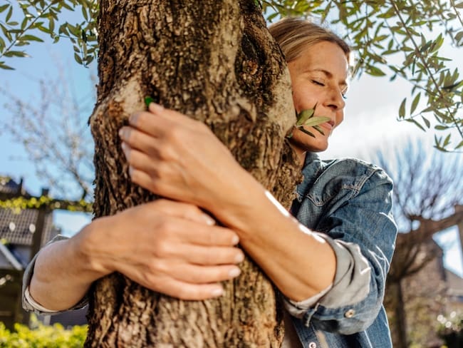 Mujer abrazando un árbol // Foto de referencia: Getty Images