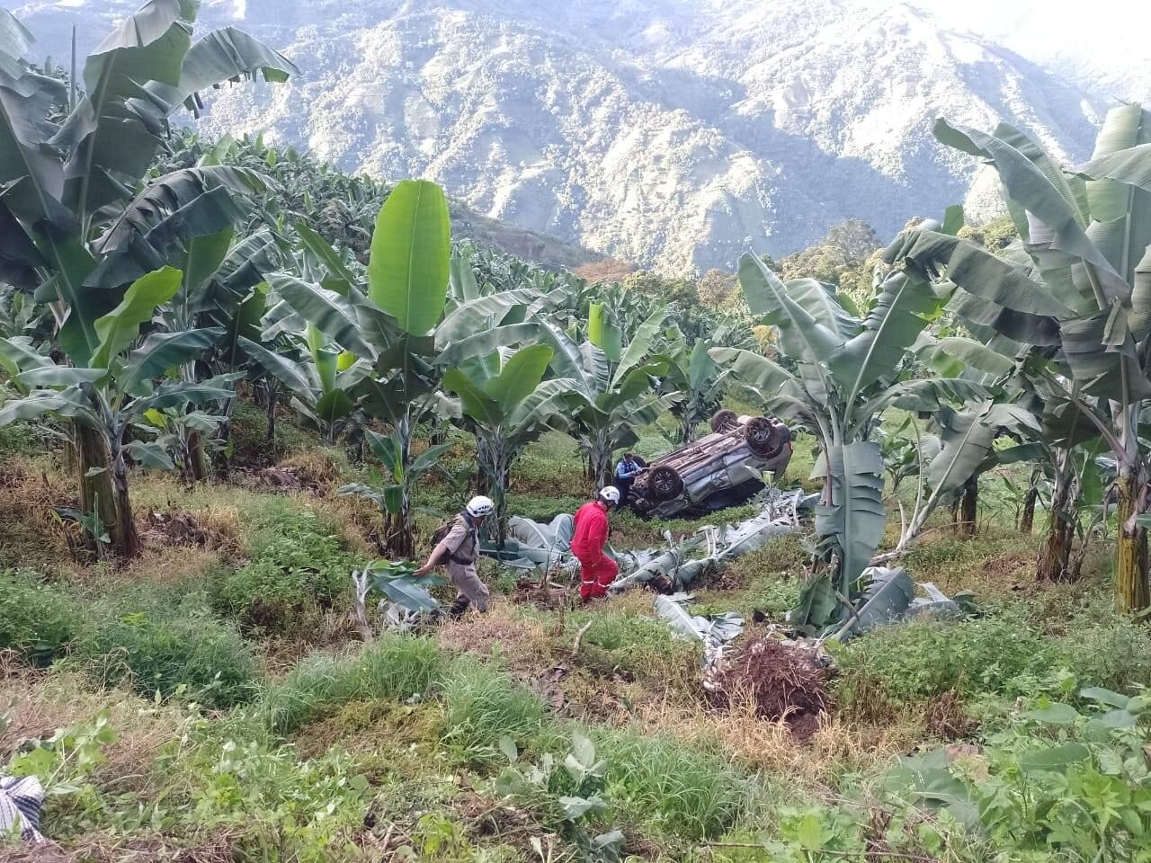 Integrantes de bomberos rescatando a las ocupantes de la camioneta que rodó por una ladera en el norte de Caldas. Foto: Cuerpo de bomberos de Pácora.