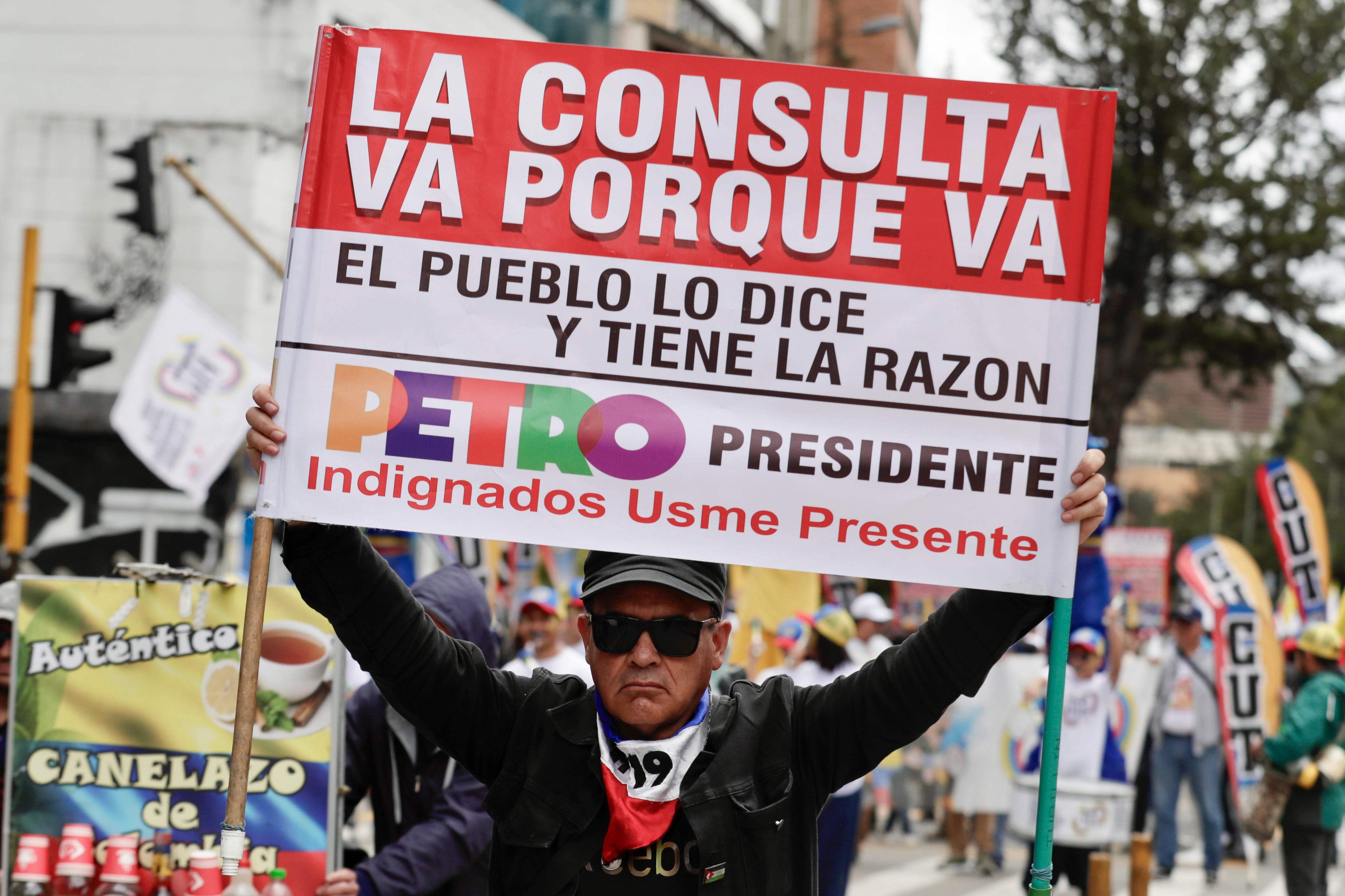 AME1451. BOGOTÁ (COLOMBIA), 28/05/2025.- Una persona sostiene un cartel durante una marcha en el primer día del paro nacional este miércoles, en Bogotá (Colombia). El "gran paro nacional" de Colombia, convocado por centrales obreras para respaldar la consulta popular y las reformas sociales del Gobierno, comenzó con bloqueos de portales de transporte público en Bogotá y poca afluencia a las manifestaciones. EFE/ Carlos Ortega