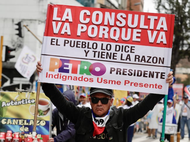 AME1451. BOGOTÁ (COLOMBIA), 28/05/2025.- Una persona sostiene un cartel durante una marcha en el primer día del paro nacional este miércoles, en Bogotá (Colombia). El "gran paro nacional" de Colombia, convocado por centrales obreras para respaldar la consulta popular y las reformas sociales del Gobierno, comenzó con bloqueos de portales de transporte público en Bogotá y poca afluencia a las manifestaciones. EFE/ Carlos Ortega