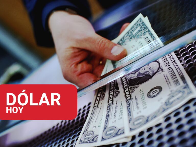 Persona entregando dólares estadounidenses a través de una ventanilla (Foto vía Getty Images)