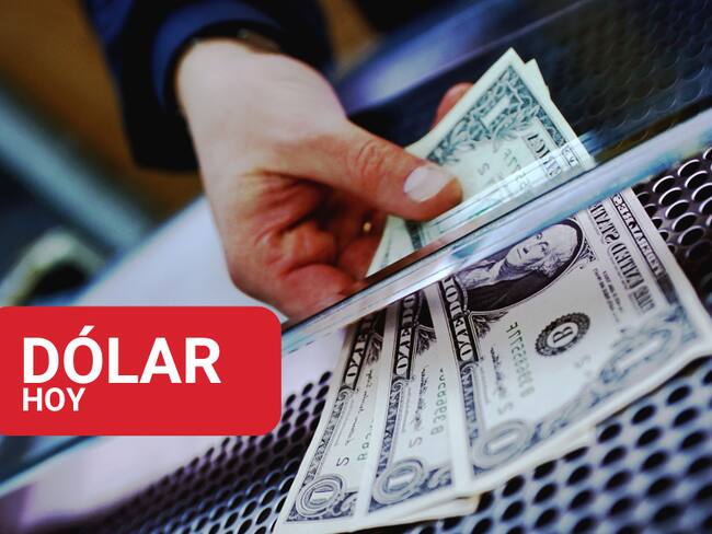 Persona entregando dólares estadounidenses a través de una ventanilla (Foto vía Getty Images)