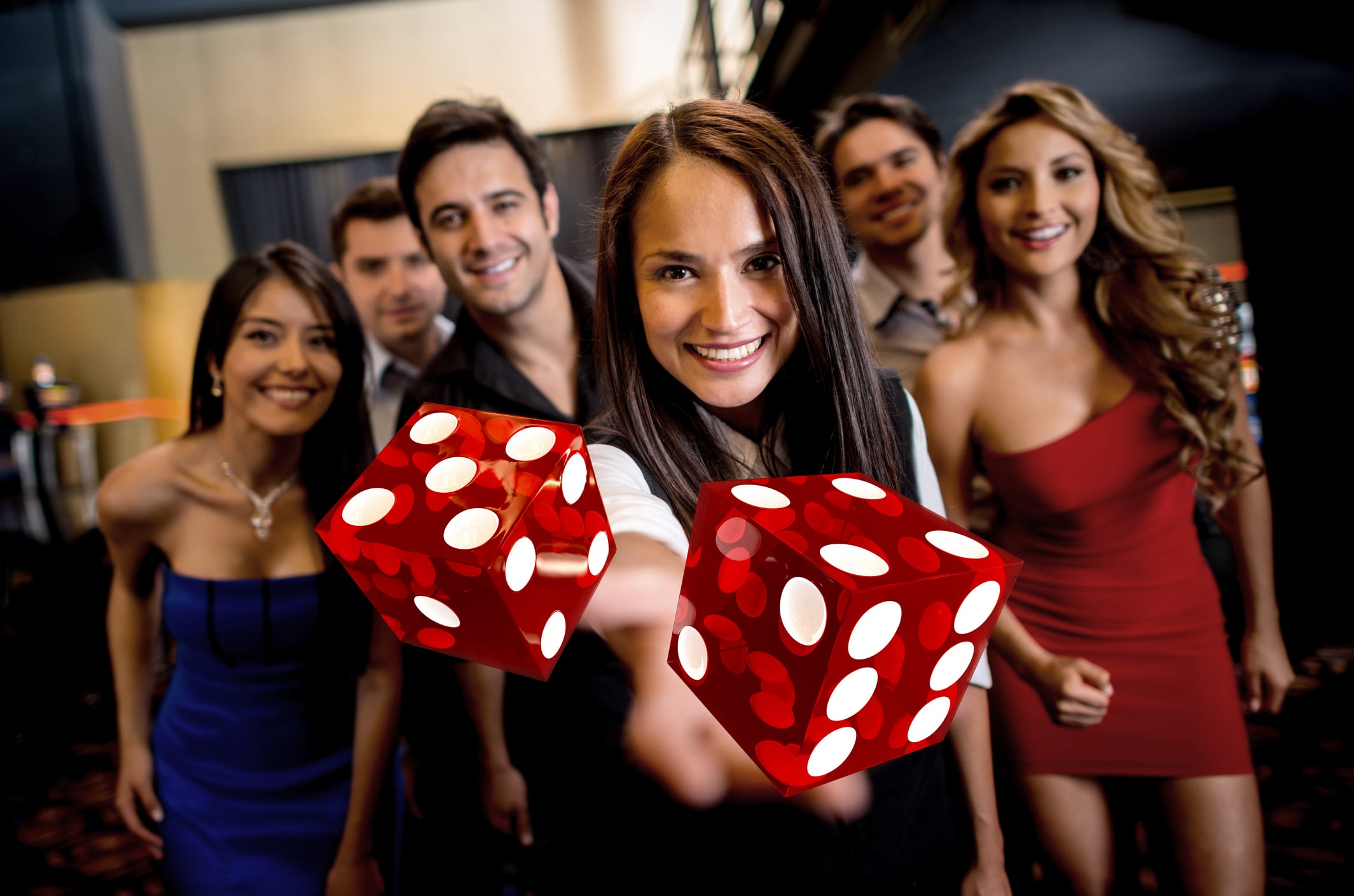 Group of people at the casino and dealer throwing dices