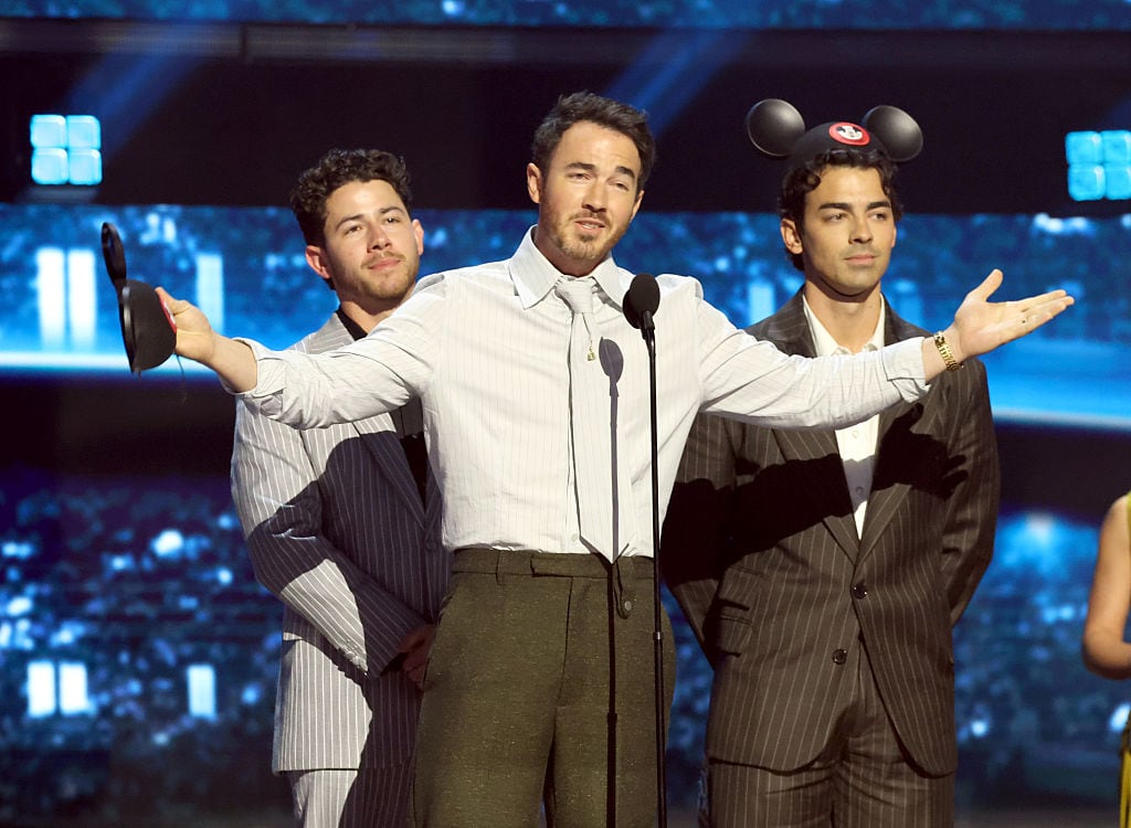 ANAHEIM, CALIFORNIA - AUGUST 16: Disney Legends award recipients (L-R) Nick Jonas, Kevin Jonas and Joe Jonas of The Jonas Brothers speak onstage at the Disney Entertainment Showcase at D23: Legends on August 16, 2026 in Anaheim, California. (Photo by Kevin Mazur/Getty Images for Disney)